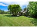 Exterior of home with large, well-manicured lawn and mature trees creating a serene setting at 33 Kay Ne Rd, White, GA 30184