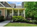Inviting covered front porch with decorative wreath, wood railing, and manicured landscaping at 33 Kay Ne Rd, White, GA 30184