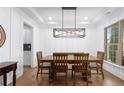 Bright dining room featuring wainscoting, modern light fixture, and an adjacent butler's pantry at 800 Ivy Crest Ln, Canton, GA 30115