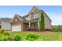 Beautiful home exterior featuring brick, siding, a manicured lawn, and colorful landscaping at 800 Ivy Crest Ln, Canton, GA 30115
