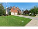 Traditional brick home with a well-maintained lawn, two-car garage, and mature trees at 2436 Camden Lake Nw Vw, Acworth, GA 30101