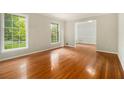 Bright living room with gleaming hardwood floors and large windows showcasing the outdoor view at 3743 Tree Bark Trl, Decatur, GA 30034
