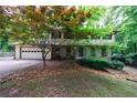 Beautiful two-story home with stone details, mature trees, and an attached garage at 10565 Shallowford Rd, Roswell, GA 30075