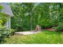 A spacious backyard featuring a stone fireplace, paved patio, and lush green lawn at 4825 Brighton Lake Dr, Cumming, GA 30040
