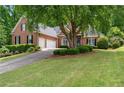 Charming brick home featuring a lush lawn, mature landscaping, and an attached two-car garage at 4825 Brighton Lake Dr, Cumming, GA 30040