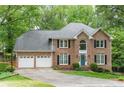 Elegant two-story brick home with a manicured lawn and a two-car garage and black shutters at 3157 Sawyer Ne Ct, Marietta, GA 30066