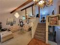 Open concept living room with staircase, chandelier, and view of kitchen through a mirrored beam at 3723 Raiders Ridge Dr, Lithonia, GA 30038