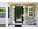 Close up of a beautiful front door with stone accents and a modern design at 5512 Village Rdg, Fairburn, GA 30213