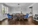 Elegant dining room featuring hardwood floors, wainscoting, a modern chandelier, and ample natural light at 238 Harmony Lake Dr, Canton, GA 30115