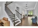 Grand foyer with hardwood floors, a staircase with iron railings, and a view of the front entrance at 238 Harmony Lake Dr, Canton, GA 30115
