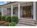 Inviting front porch featuring a cozy swing, elegant double doors adorned with wreaths, and well-maintained landscaping at 238 Harmony Lake Dr, Canton, GA 30115