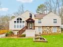 Home featuring large windows, stone accents, a covered entry, landscaped yard, and a decorative fountain at 3748 Woodrose Ct, Snellville, GA 30039