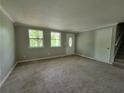 Large carpeted living room, neutral paint, front door and a stairway to the second level at 4063 Feather Dr, Douglasville, GA 30135