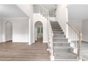 Elegant foyer featuring a grand staircase, hardwood floors, and neutral tones, creating a welcoming ambiance at 2111 Fernbank Way, Dacula, GA 30019