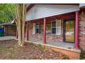A quaint front porch features brick columns and offers a shaded area to relax near the yard at 3082 Corbin Ave, Decatur, GA 30034