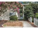 Charming exterior view of the home with blooming trees, a picket fence, and a stairway at 1418 Foxhall Se Ln # 18, Atlanta, GA 30316