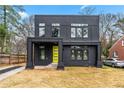 Modern two-story home with a striking black facade, complemented by a vibrant yellow front door at 2402 Lynn Iris Dr, Decatur, GA 30032