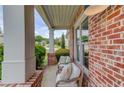 Cozy covered porch with brick accents and comfortable seating, perfect for relaxing outdoors at 2112 Ivey Chase Dr, Dacula, GA 30019