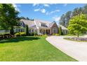 Beautiful home with lush green lawn, mature trees, and manicured landscaping on a sunny day at 101 Morgan Ln, Canton, GA 30115