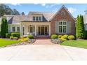 Inviting home featuring a brick front porch, classic columns, and lush landscaping at 101 Morgan Ln, Canton, GA 30115