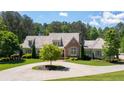 Charming home featuring a circular driveway, landscaped yard, and a mix of brick and siding exterior at 101 Morgan Ln, Canton, GA 30115