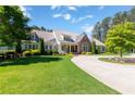 Beautiful two-story home with a circular driveway, lush lawn, and manicured landscaping at 101 Morgan Ln, Canton, GA 30115