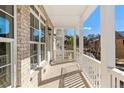 Inviting covered porch with brick flooring, white columns, and ample natural light, creating an outdoor oasis at 2035 Parkside Ln, Roswell, GA 30076