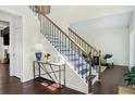 Staircase with hardwood treads, white risers, and a decorative console table at 2123 Indian Ivey Ln, Dacula, GA 30019