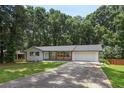 Quaint single story home featuring an attached garage and a concrete driveway at 3918 Artist Vw, Decatur, GA 30034