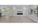 Cozy living room with modern fireplace, large windows, and wood-style flooring at 3918 Artist Vw, Decatur, GA 30034