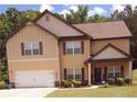 Inviting two-story home with a garage and a cozy front porch, landscaped with bushes and small trees at 504 Liverpool Dr, Mcdonough, GA 30252