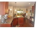 Bright eat-in kitchen with wood cabinets, granite countertops, stainless steel appliances, and hardwood floors at 504 Liverpool Dr, Mcdonough, GA 30252