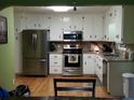 Updated kitchen with stainless steel appliances, granite countertops, and white cabinets, offering both style and functionality at 22 Briar Chase Ct, White, GA 30184