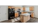 Functional kitchen featuring light wood cabinetry, black appliances, and a convenient center island at 229 Millwheel Dr, Villa Rica, GA 30180