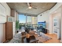 Inviting living room with stylish furniture, a ceiling fan, and an open doorway to the bedroom at 3324 Peachtree Ne Rd # 1104, Atlanta, GA 30326