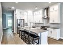 Bright kitchen featuring white cabinets, a gray countertop island with seating, and stainless steel appliances at 247 Franklin Rd, Atlanta, GA 30342