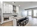 Modern, all-white kitchen featuring an island with barstool seating and stainless steel appliances at 247 Franklin Rd, Atlanta, GA 30342