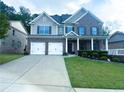 Lovely two-story brick home with a well-maintained lawn, inviting porch, and a convenient two-car garage at 545 Eldridge Dr, Suwanee, GA 30024