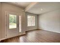 Bright living room with hardwood floors, a double-door entry, and natural light streaming through the windows at 911 Park Place St, Social Circle, GA 30025