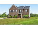 Two-story brick home with dark shutters and lush green lawn at 229 Prescott St, Locust Grove, GA 30248