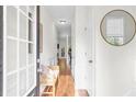 Bright hallway with hardwood floors, wainscoting, bench and a view to the exterior through glass doors at 3562 Greenwich Ave, Duluth, GA 30096