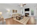 Comfortable living room featuring a fireplace, hardwood floors, neutral decor, and abundant natural light at 3562 Greenwich Ave, Duluth, GA 30096
