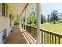 Covered porch with classic columns, decorative lighting, and a serene outdoor view at 11433 Panhandle Rd, Hampton, GA 30228