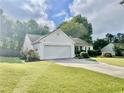 Well-maintained front yard with a lush lawn, mature landscaping, and a two-car garage at 431 Crested View Dr, Loganville, GA 30052