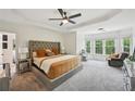 Spacious primary bedroom featuring a tray ceiling, plush carpeting, and ample natural light at 75 Vinings Lake Sw Dr, Mableton, GA 30126