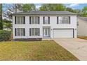 Charming two-story white brick home featuring a well-manicured lawn, attached garage, and classic curb appeal at 285 Camden Park Dr, Lawrenceville, GA 30046