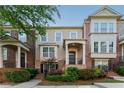 Charming townhome with brick accents, a welcoming front porch, and manicured landscaping at 2313 Millhaven St, Smyrna, GA 30080