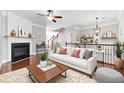 Cozy living room featuring a fireplace, ceiling fan, and staircase access at 2313 Millhaven St, Smyrna, GA 30080