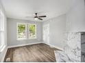 Bright living room with hardwood floors, a modern ceiling fan, and a decorative fireplace at 554 Lawton Sw St, Atlanta, GA 30310