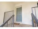 Close-up of the front door with a welcome mat and wrought iron railing at 133 Maison Nw Pl, Atlanta, GA 30327
